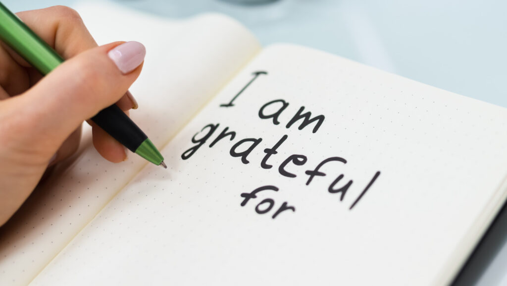 A person writing in a gratitude journal, captioned “Gratitude for self-improvement.”